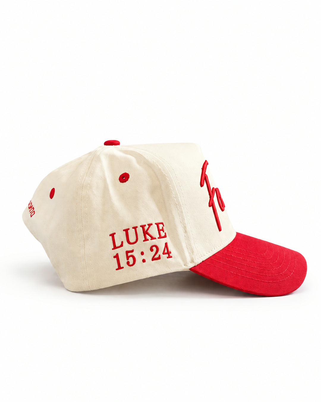 Found Cap in cream with red bill, side view showing LUKE 15:24